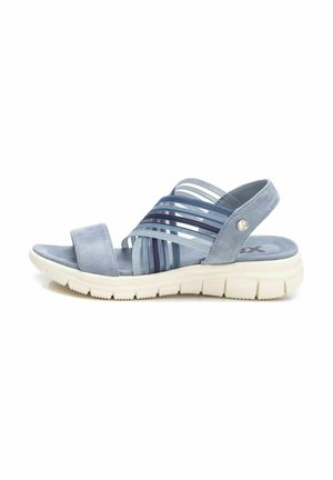 Sandalia azul de material de gamuza suave, presenta tiras horizontales de diferentes tonalidades y una suela de goma blanca con un patrón texturizado.