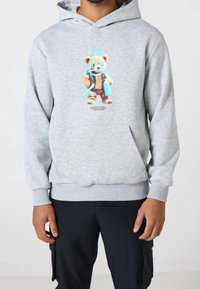 Felpa grigia con grafica frontale di un orso cartoon con accenti blu. Realizzata in tessuto morbido, con tasca a canguro e polsini a costine.