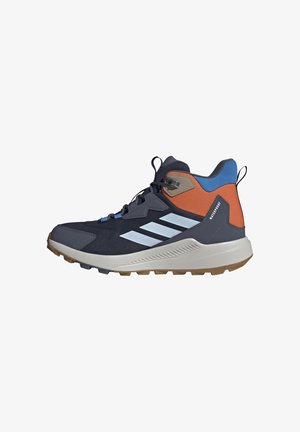 Wasserdichter Wanderschuh mit hohem Schaft, schwarzen, orangen und blauen Einsätzen, weißer Sohle, strukturiertem Grip und Schnürverschluss.