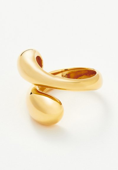 Λαμπερό χρυσό δαχτυλίδι με λείο, αφηρημένο καμπυλωτό σχέδιο που διαθέτει δύο στρογγυλεμένες άκρες, σε απλό λευκό φόντο.