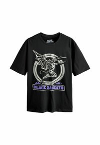 Sort T-shirt med hvid vinget dæmon grafisk inden i en cirkel og lilla "Black Sabbath" tekst nedenfor.