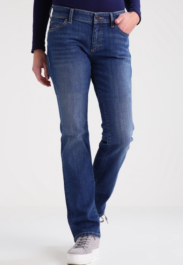 Jeans in denim blu con taglio dritto, caratterizzati da un classico design a cinque tasche e un leggero sbiadimento. Abbinati a sneakers grigie.