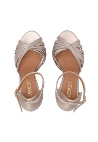 Beige Riemchenhochzeitsschuhe mit einer glatten Lederoberfläche, offener Zehenpartie und einem Knöchelriemen mit einer goldenen Schnalle.