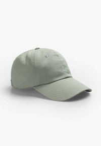 Grøn bomulds-baseballkasket med bøjet skygge, broderet logo på fronten og ventilationshuller på siderne.