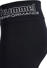 Czarne legginsy sportowe z wysokim stanem. Z przodu znajduje się białe logo "hummel PERFORMANCE", gładka faktura materiału oraz bezszwowy design.