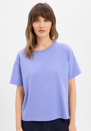 Fliederfarbenes Baumwoll-T-Shirt mit kurzen Ärmeln, Rundhalsausschnitt, lockerem Schnitt und glatter Textur. Keine sichtbaren Muster oder Verzierungen.