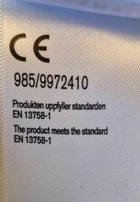 Vit tygetik med svart text, inklusive "CE," produktkod 985/9972410 och information om överensstämmelse på svenska och engelska.