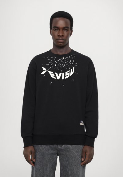 Sweatshirt noir avec un logo blanc et des accents en pixels sur la poitrine. Tissu doux, col rond, et poignets et ourlet côtelés.