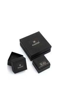 Schwarze Kartons aus Pappe in verschiedenen Größen mit glatter Oberfläche und aufgedrucktem Logo. Eine Schachtel ist teilweise geöffnet, sodass das Innere sichtbar ist.