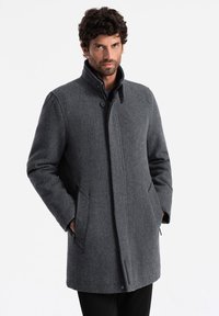 Abrigo de mezcla de lana gris para hombre con cuello alto, cierres de botones, bolsillos laterales y corte recto, que presenta una textura suave y una tela lisa.