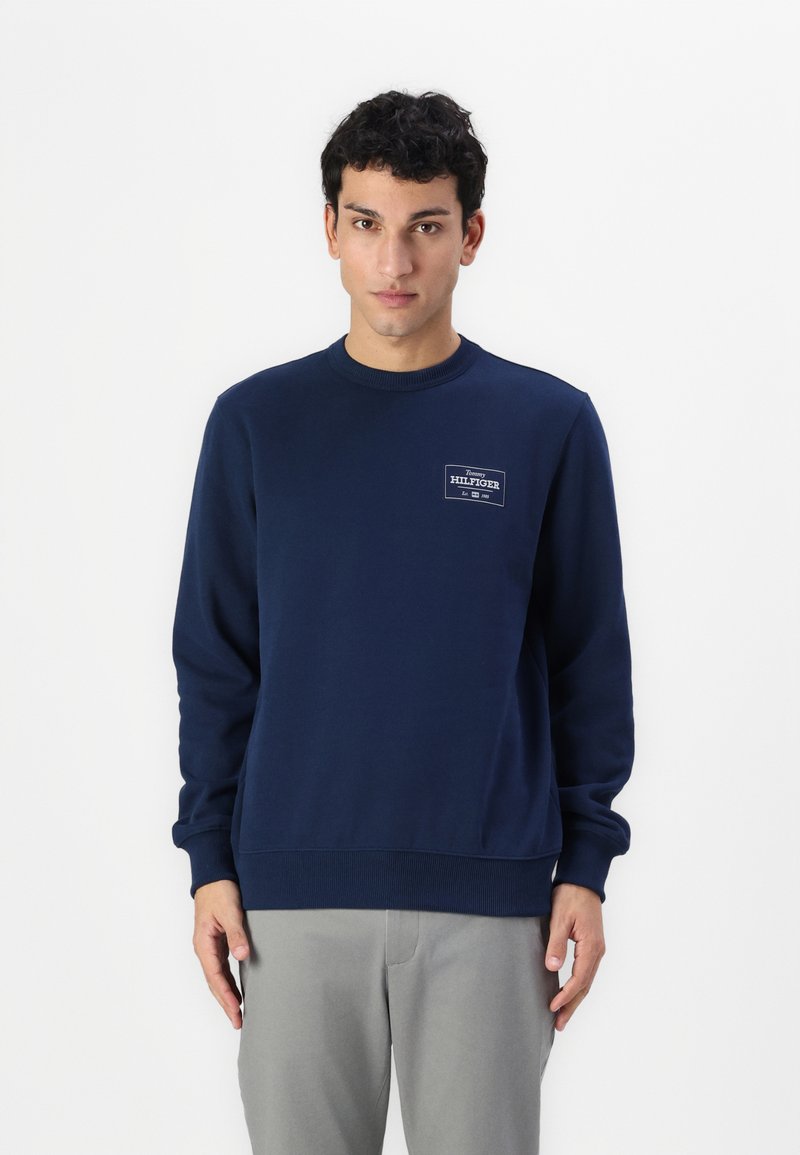 Sudadera azul marino hecha de mezcla de algodón, con un cuello redondo, puños de canalé y un pequeño parche de logo en el pecho.