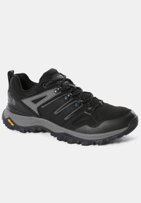 Chaussure de randonnée robuste noire et grise avec une semelle Vibram épaisse, un design à lacets et un col rembourré pour une utilisation en extérieur.