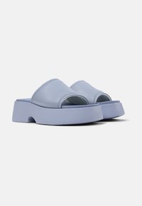 Sandali slide in pelle azzurro chiaro con punta aperta e una suola chunky e testurizzata. Il design presenta curve morbide e uno stile minimalista.