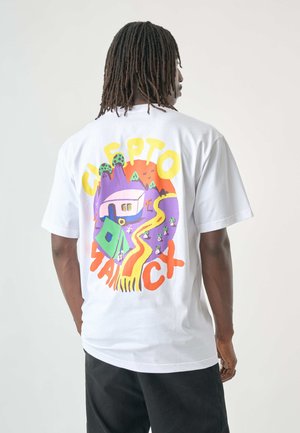 Weißes Baumwoll-T-Shirt mit einem bunten Grafikdesign, das eine Berglandschaft, eine Straße und einen Campingplatz zeigt; auffälliger Text "CAPT" und "MANICX." Kurzärmlig.