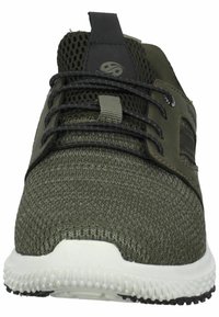 Zapatilla deportiva de malla en verde oliva con cordones y ojetes negros. Presenta una suela blanca con acabado texturizado y acentos negros en el costado.