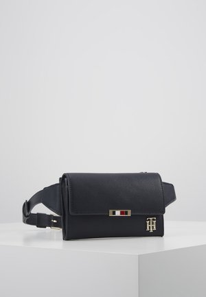 Sac bandoulière en cuir noir grainé avec rabat, quincaillerie dorée et un panneau accent rayé. Sangle ajustable et détails de logo en relief.