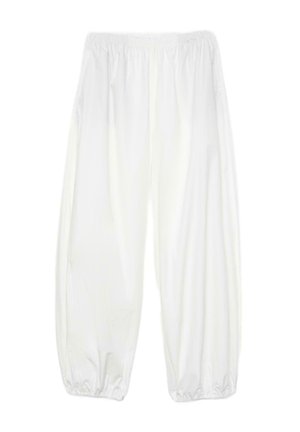 Ohlapne bele hlače z elastičnim pasom in elastičnimi manšetami na gležnjih, zasnovane za sproščeno prileganje.