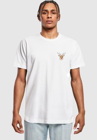Witte katoenen t-shirt met een klein, cartoon rendierontwerp met hoorns en een rode neus op de linkerkant van de borst, korte mouwen, relaxed fit.