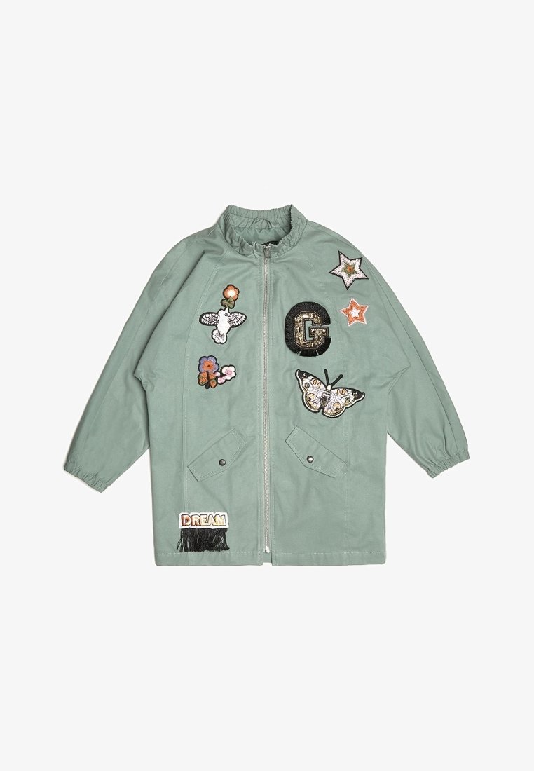 Miętowa zielona kurtka na zamek z przodu, z elastycznymi ściągaczami przy rękawach oraz dekoracyjnymi naszywkami, w tym motylami, kwiatami i gwiazdkami. Posiada przednie kieszenie.