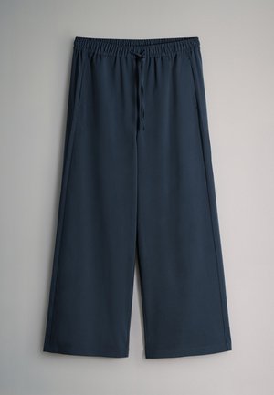 Dark blue wide-leg pants with elastic waistband and drawstring, featuring side pockets, displayed against a light grey background.