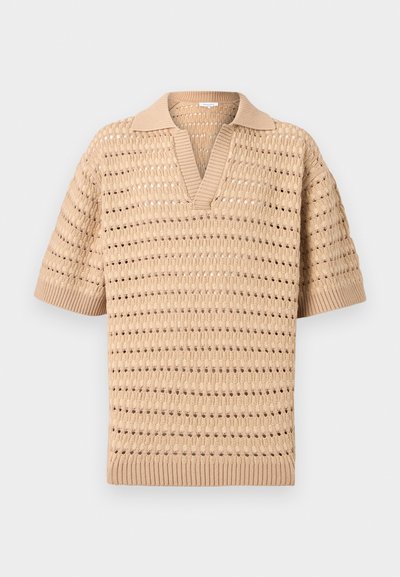 Μπεζ πλεκτό πόλο με κοντά μανίκια, διάτρητο μοτίβο και ραβδωτό γιακά, μανσέτες και τελείωμα, απλωμένο σε φωτεινό φόντο.