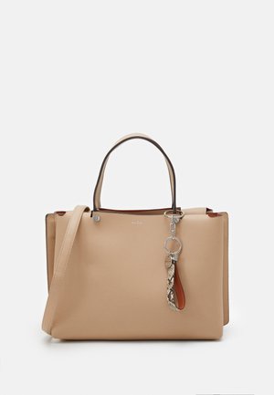 Bolso de mano de cuero beige con doble asa, correa desmontable para el hombro y un accesorio llavero plateado con un aro de diseño de piel de serpiente.