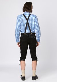 Black leather shorts with suspenders, paired with a blue and white checkered shirt, featuring cuffs and adjustable ties at the hem.