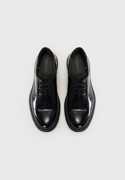 Black leather shoes with a smooth, shiny finish, rounded toe, five-eyelet lace-up design, and contrasting rubber sole.