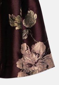 Kort lilla blomsterstoff med en blank tekstur, som har store gull- og rosa blomster og mørkegrønne aksenter langs kanten.