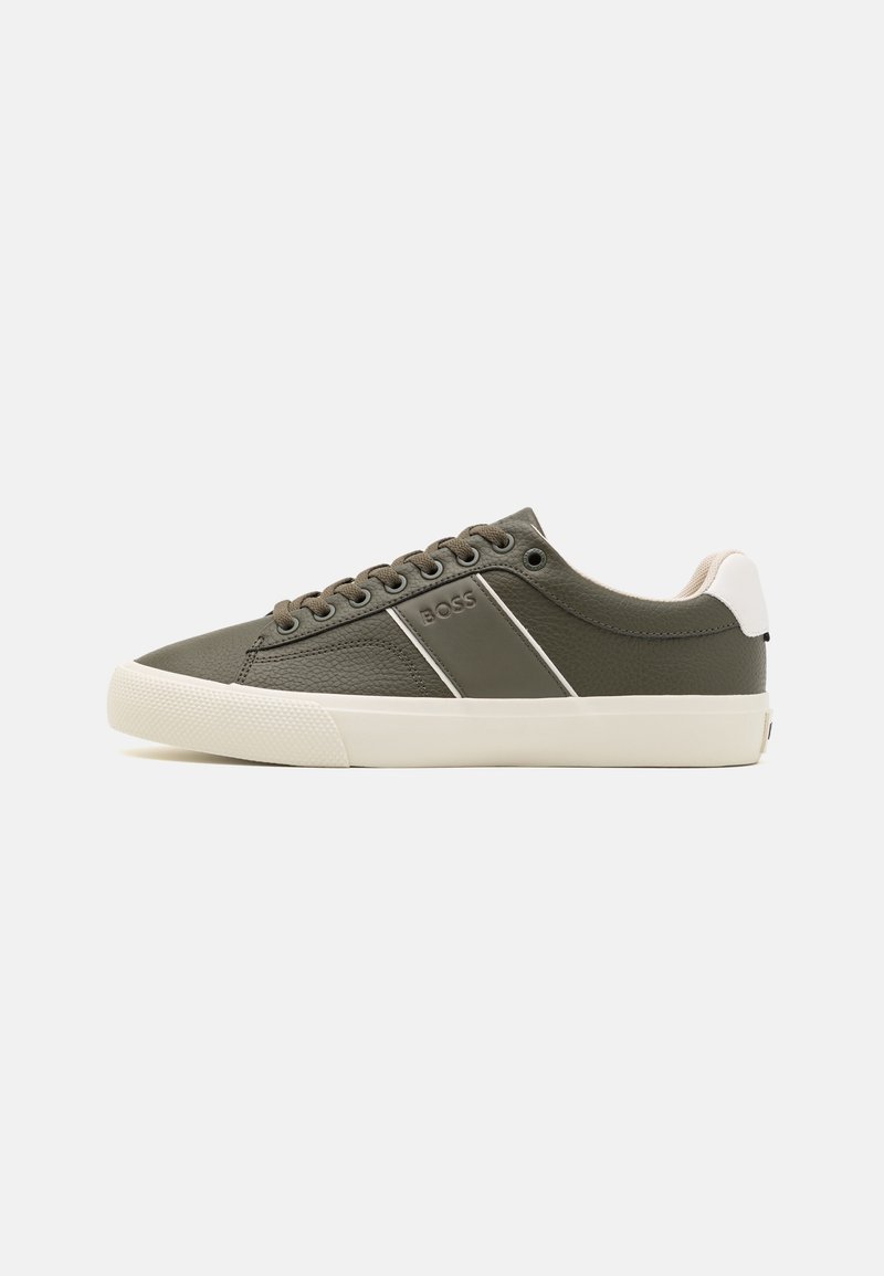 Baskets basses vert olive avec semelle blanche, lacets et accent talon, avec le logo "BOSS" sur le panneau latéral.
