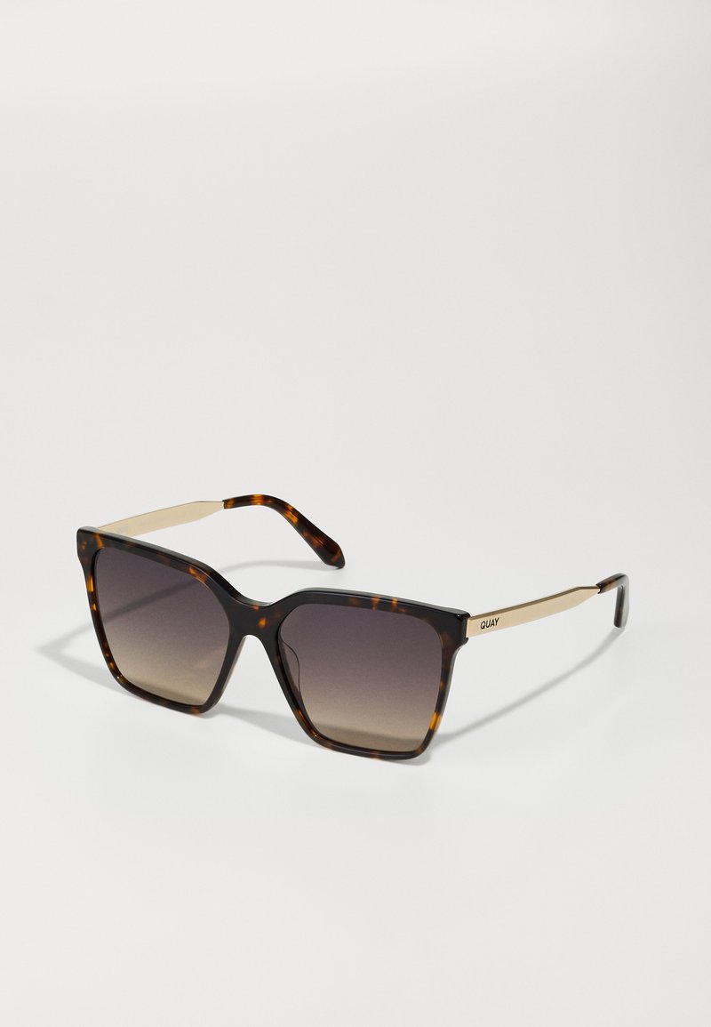 Ochelari de soare din material tartan cu un design pătrat, lentile degrade și accente din metal de ton auriu pe brate. Rame din plastic ușor.