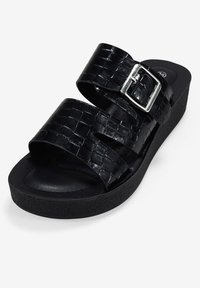 Sandalias de plataforma negras con dos correas anchas que presentan una textura de cocodrilo y una hebilla plateada. Plantilla suave y suela de goma.
