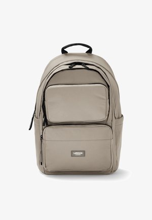 Sac à dos beige avec plusieurs compartiments, fermetures éclair et une poignée supérieure. Fabriqué en tissu texturé, doté d'un patch logo à l'avant.