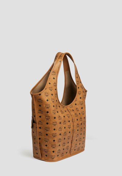Beżowa torebka hobo z sztucznej skóry, zdobiona wzorem logo, z dwoma uchwytami na ramię oraz pojemnym wnętrzem o gładkiej teksturze i eleganckim kształcie.