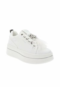 Zapatilla blanca con suela gruesa, material de cuero, adornos florales plateados y acentos de plumas. Presenta cierre con cordones y una pestaña negra en contraste.