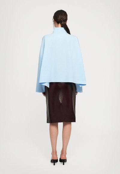 Light blue cape with a high collar, paired with a burgundy leather pencil skirt. Smooth texture, minimal design, and no visible patterns.