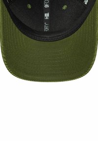 Grüne Kappe mit schwarzem Schild, aus strukturiertem Stoff und sichtbaren Nähten. Das Innere enthält bedruckte Etiketten und eine dunkle Fütterung.
