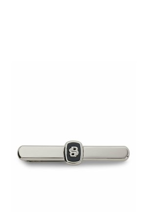 Srebrna metalowa spinka do krawata z czarnym środkiem, na którym znajduje się stylizowana litera „B”.