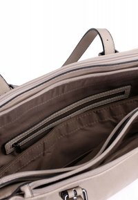 Beige handtas met meerdere compartimenten, waaronder een ritsvak, gemaakt van soepel leer en met een zachte stoffen voering. Voorzien van contrasterende steken.