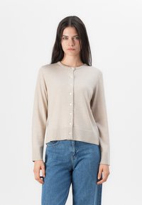Beige cardigan med rund halslinje, ribbestrikket kant og lange ermer. Har knappestolpe med fem små, runde knapper.