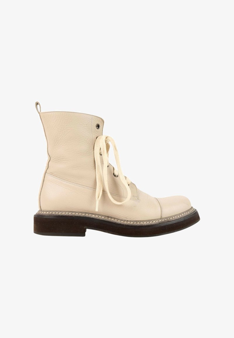 Bottine en cuir couleur crème avec lacets et semelle épaisse marron foncé vue de profil sur fond blanc.