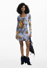 Rochie cu mânecă lungă, având un imprimeu floral și abstract în nuanțe de albastru, decolteu pătrat și dantelă; asortată cu accente unice în albastru închis la glezne.