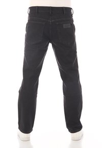 Jeans in denim nero con un design a gamba dritta, tasche posteriori e un'etichetta in pelle del marchio. Il tessuto ha una texture liscia con una leggera scoloritura.
