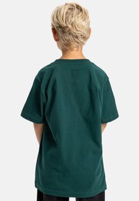 Zelené bavlněné tričko s krátkým rukávem, klasickým kulatým výstřihem a uvolněným střihem, s hladkou texturou a bez viditelných designových detailů.