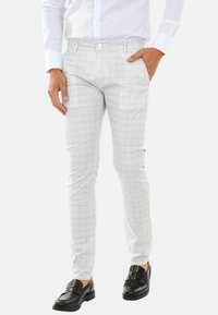 Pantaloni a quadri grigio chiaro realizzati in tessuto con una texture liscia. Presentano tasche laterali, chiusura con bottone e un design slim-fit.