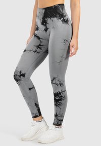 Leggings grigi alti in vita con un motivo astratto tie-dye nero e grigio, realizzati in materiale elasticizzato per comfort e libertà di movimento.
