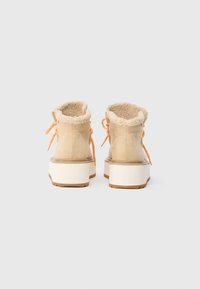Botas de tobillo de ante beige con un cuello forrado de pelo, cordones naranjas y suelas de plataforma blanca gruesa. Suela de goma texturizada para un mejor agarre.