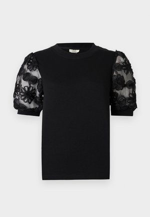 T-shirt noir avec un col rond et des manches courtes. Les manches bouffantes sont en tissu transparent avec une broderie florale noire délicate.