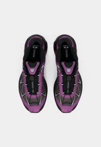 Purple and black athletic shoes with mesh upper, reflective accents, and lace-up design. Features textured outsole for grip and stability.
