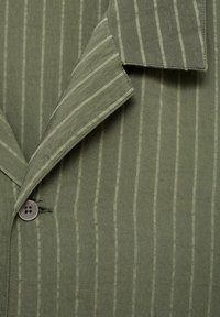 Olive green striped shirt featuring a lapel collar, button closure, and soft, textured fabric with thin contrasting white stripes.